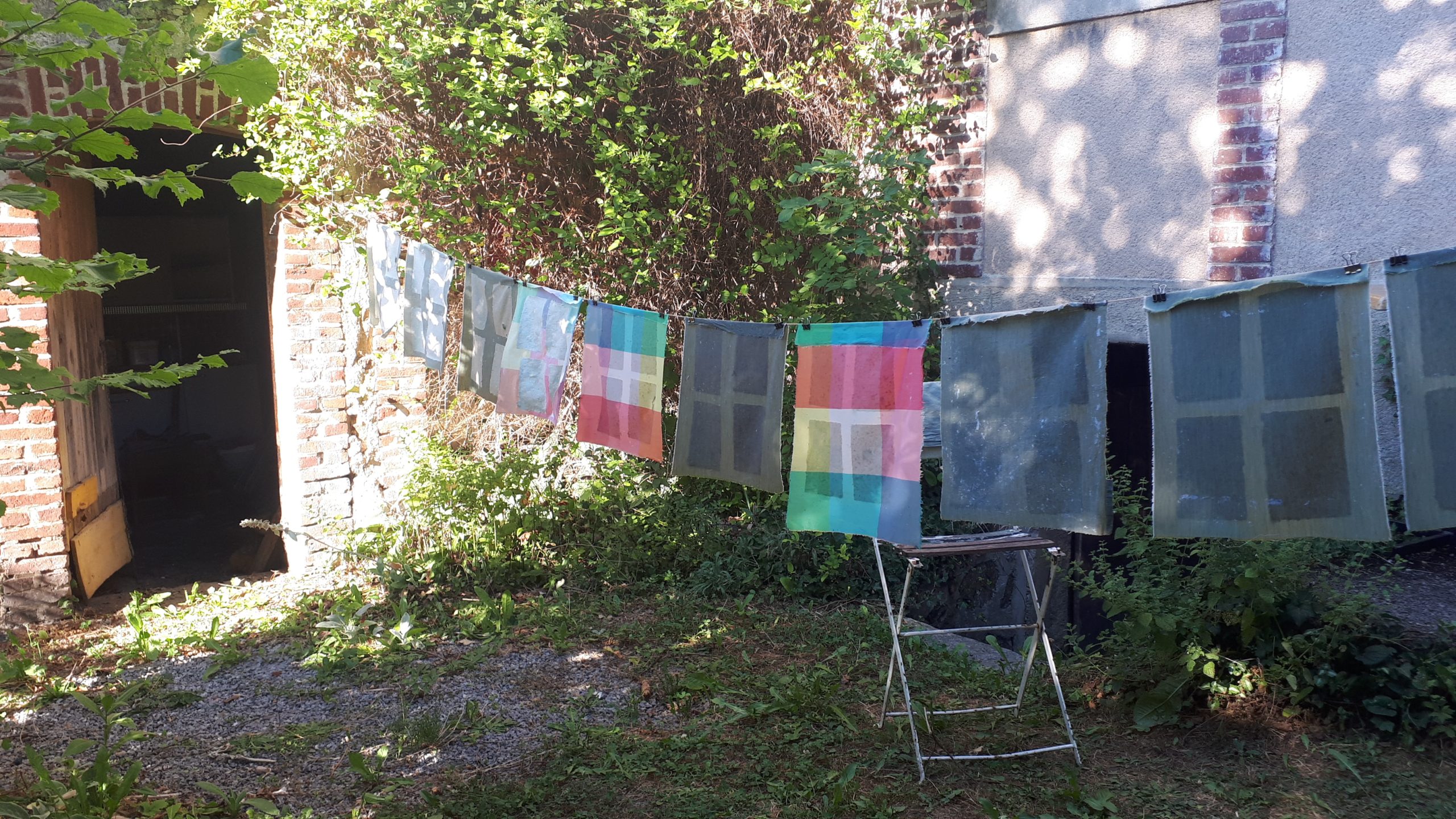 Papiers recyclés en train de sécher au soleil dans un jardin