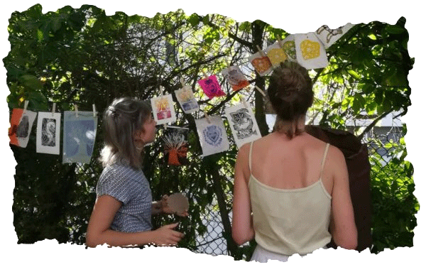 Participantes d'un atelier qui regardent leurs œuvres sécher dans un jardin